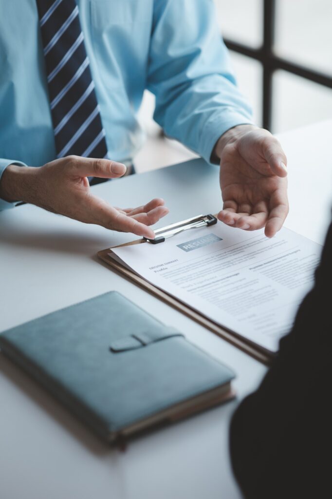 A person attends a job interview with a manager to join a company, he holds a resume and interview w